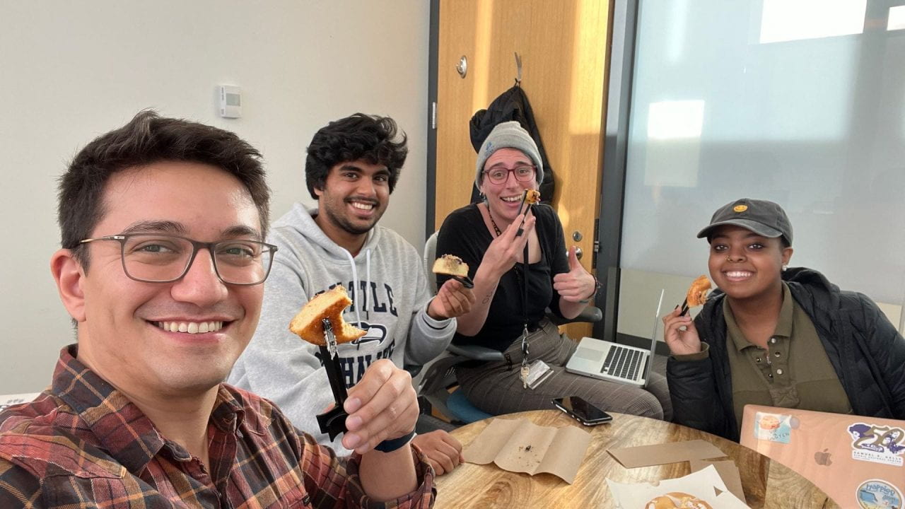 The MastuLab members have pose with their finger chopsticks and pastry during lab meeting.