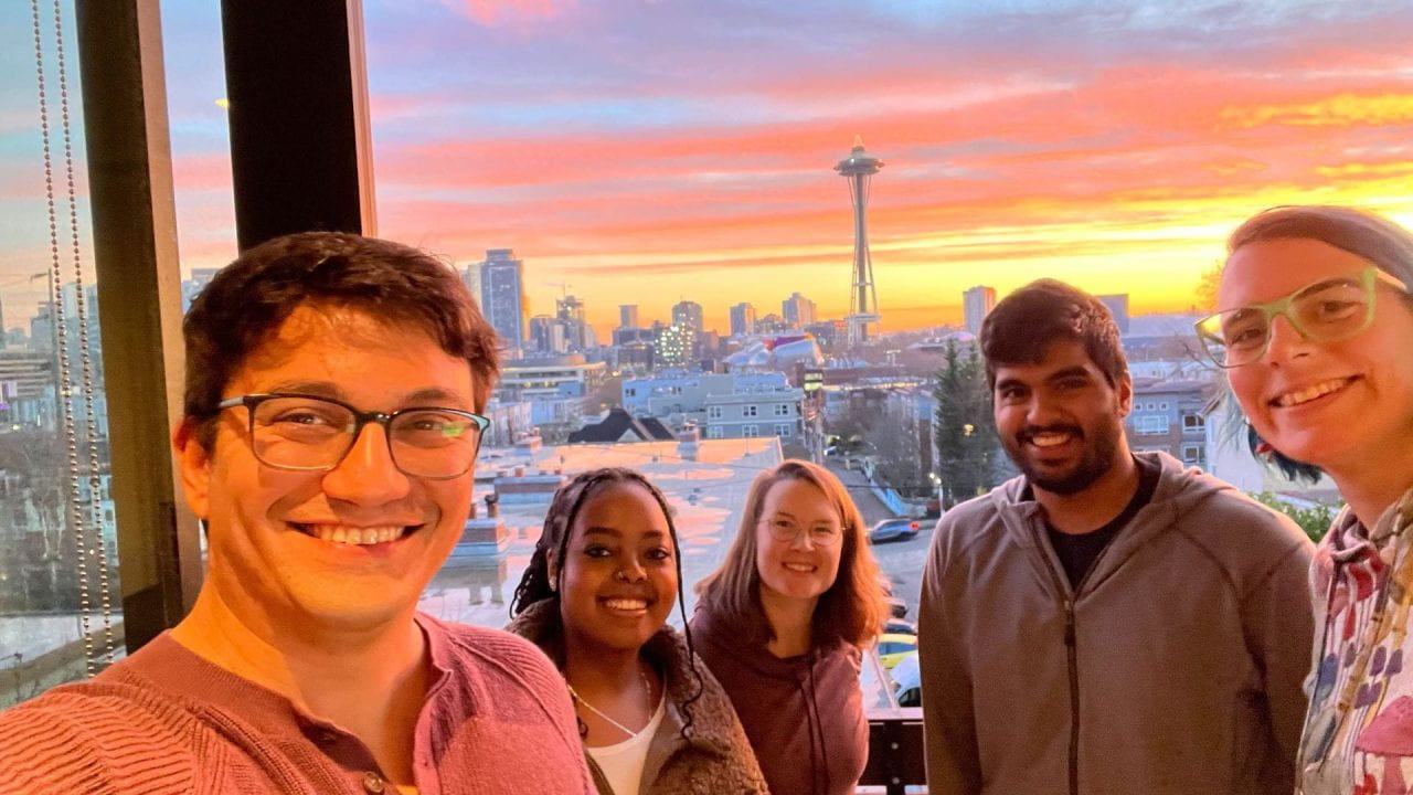 Selfie of the MatsuLab members in front of the Space Needle at sunset