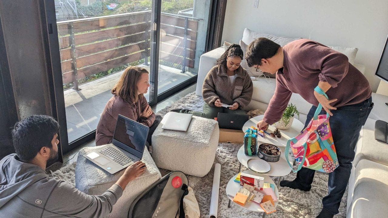 Matsulab members setting up snacks, post-its, and laptops for the lab retreat