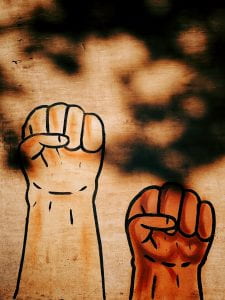 Drawing of two fists raised in solidarity on a mural. 