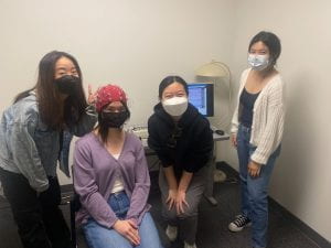 a photo of four undergraduate RAs, one with EEG cap on