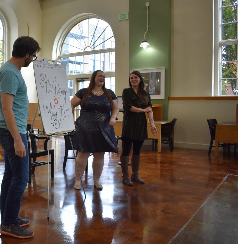 three people presenting in front of an easel