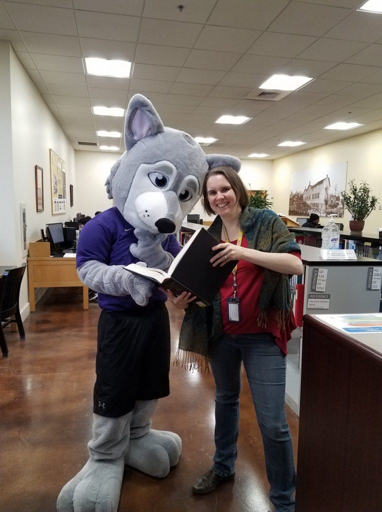 Hendrix the UW Tacoma Mascot Husky Dog with Reference Specialist Looking at an Encylopedia