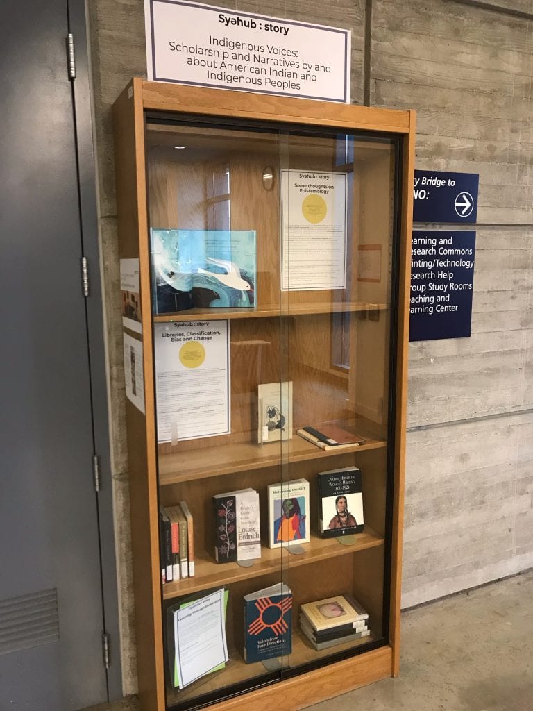 Shows a bookcase of an exhibit in a Library 