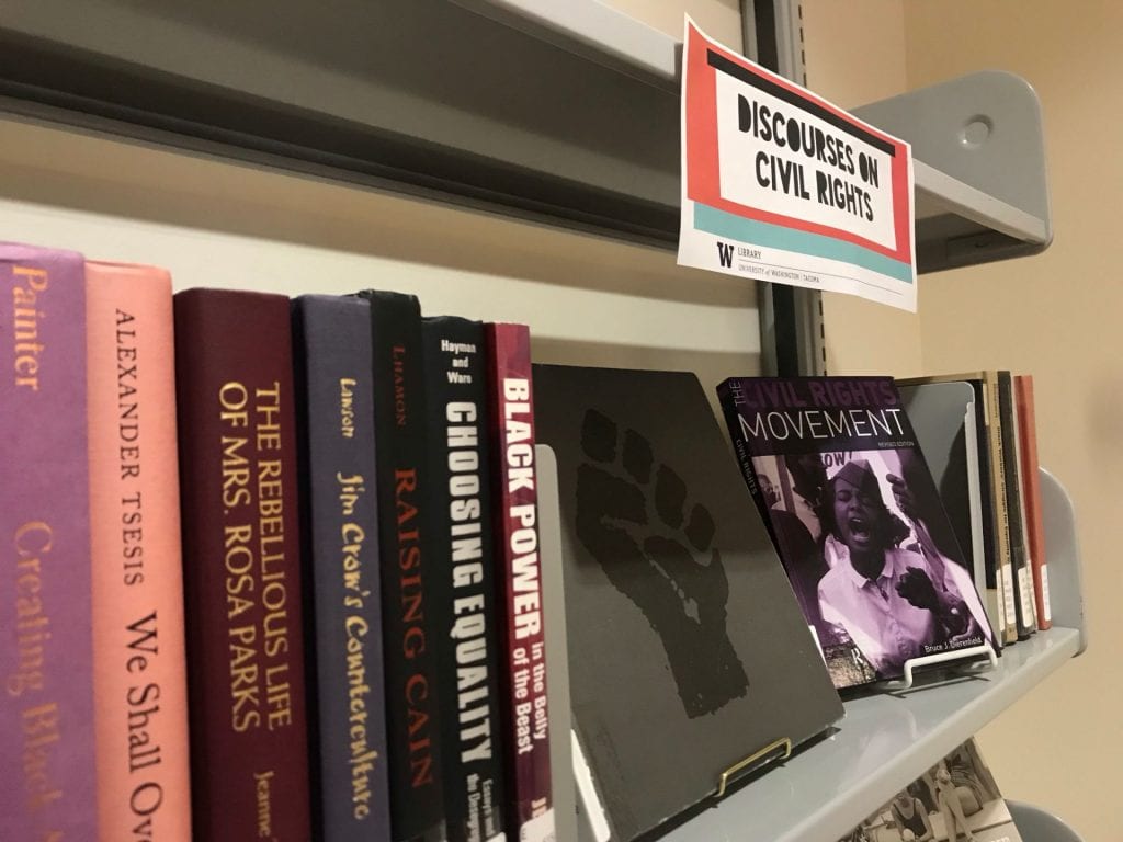 Library exhibit featuring civil rights books and a raised black power fist