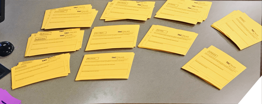 Photograph of stacks of yellow paper; these are feedback forms that will be given to presenters of the UW Tacoma TAC Talks.