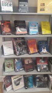 A bookshelf displaying several rows of new books.