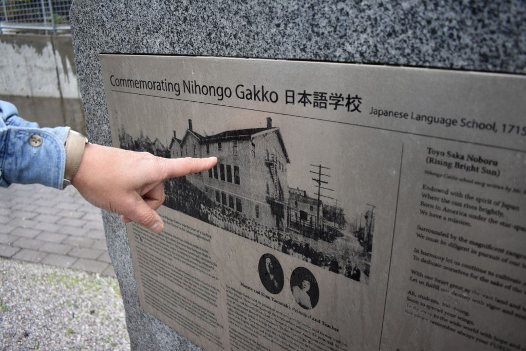 Greg Tanbara points at Japanese Language School memorial.
