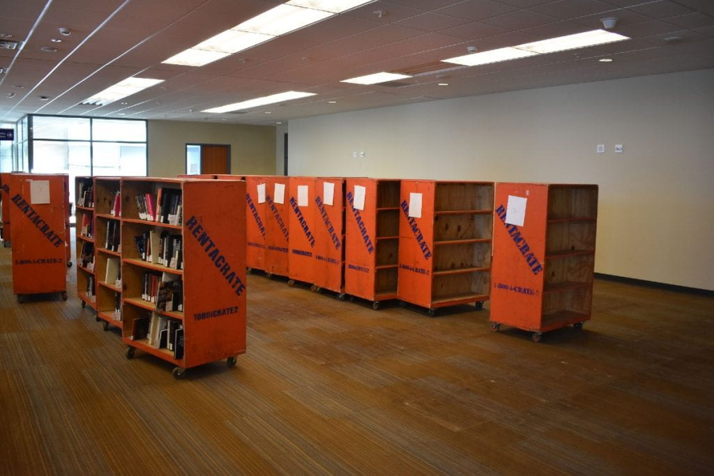 Photo of second floor Tioga Library Building taken on February 10, 2021, showing open space with book carts.