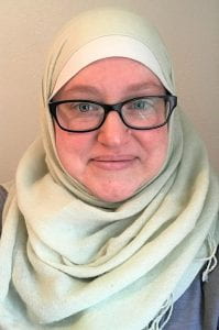 Headshot of a woman in glasses wearing a white hijab