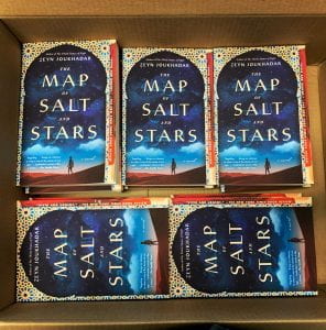 A carton of books filled to the brim: Title of book, The Map of Salt and Stars
