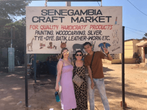 Alexis with two friends posing for a photo at the Senegambia craft market